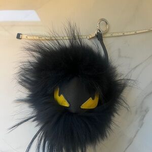 Black Furry Pom Charm with Yellow Eye Detail